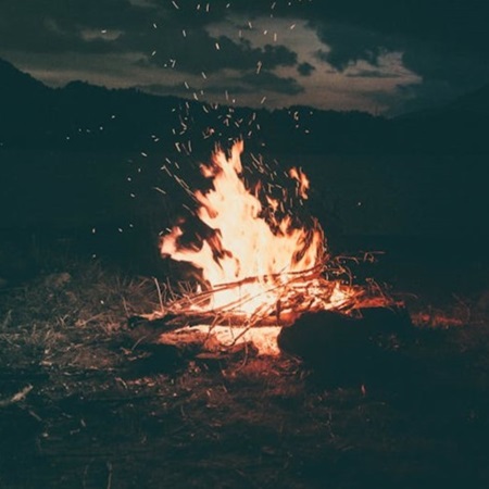 Night campfire with sparks on ancient storytelling winds.