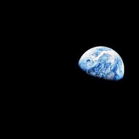 Vibrant Earth viewed from space, showcasing swirling white clouds, deep blue oceans, and lush green continents against the blackness of space.