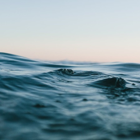 Silky deep blue ocean surface shimmering in close-up view