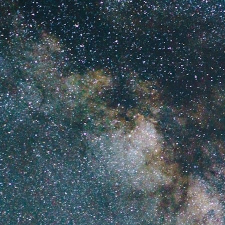 Luminous Milky Way spans the midnight sky, spilling a soft silver river of stars across the quiet darkness.